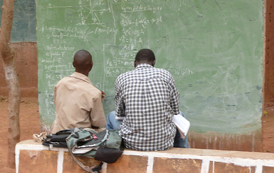 Two men study math on a chalkboard